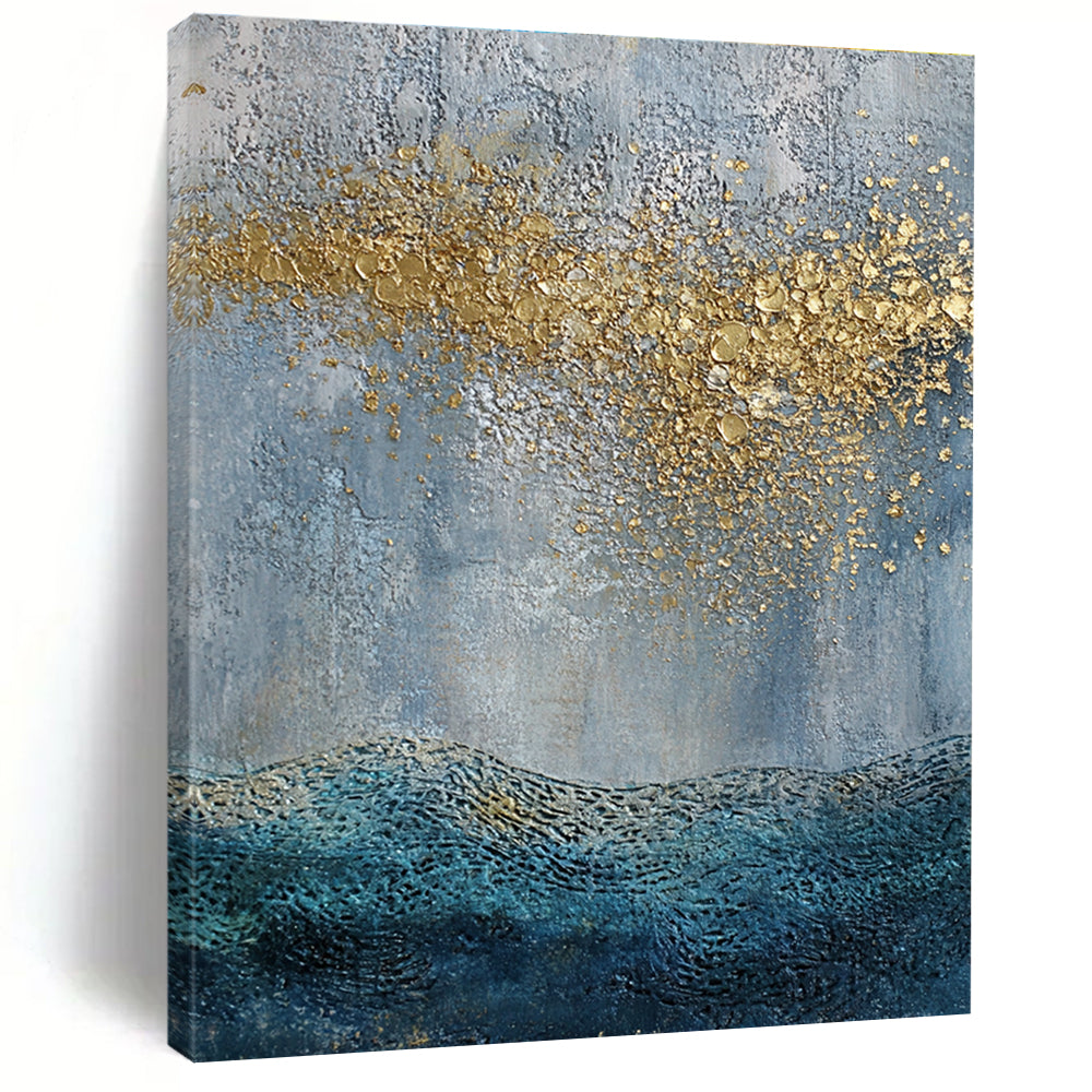 Large abstract painting with a textured sky-blue gray background and golden highlights featuring a textured sea with gentle waves in the foreground.STSC835