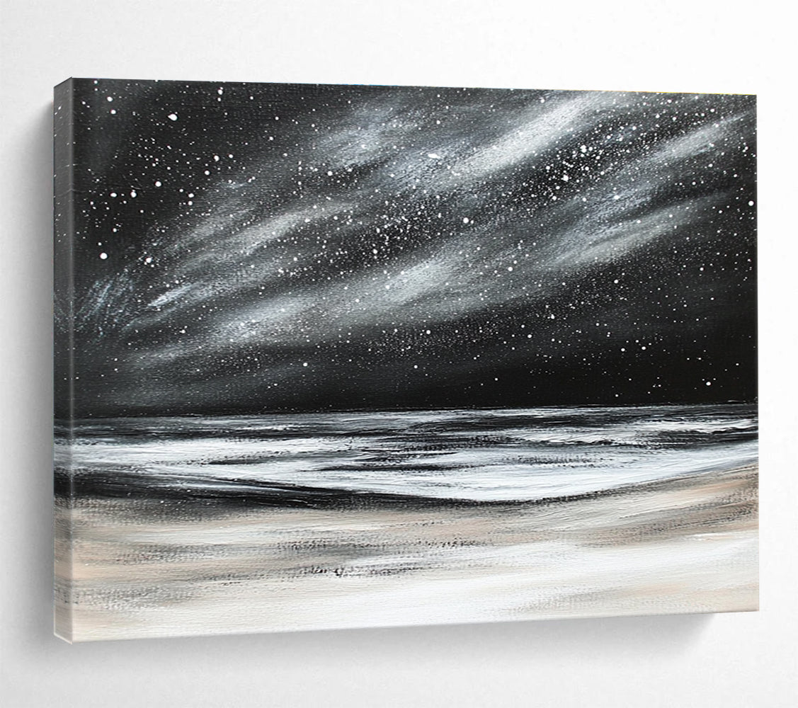 Large abstract painting depicting a dark stormy sky with stars and snow on the beach in black and white colors.SC295
