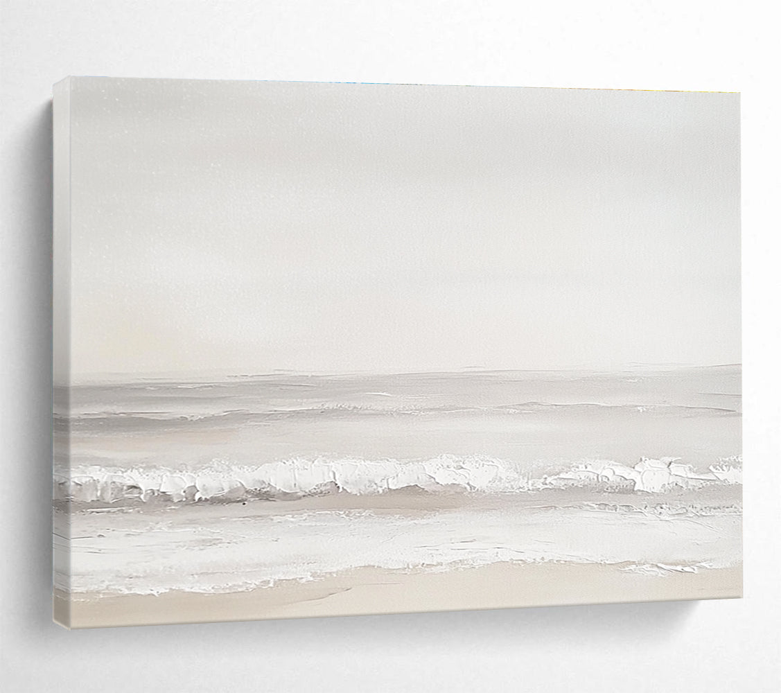 A large abstract painting of the sea featuring light gray and white tones with serene waves and a beige beach for added depth.SC502