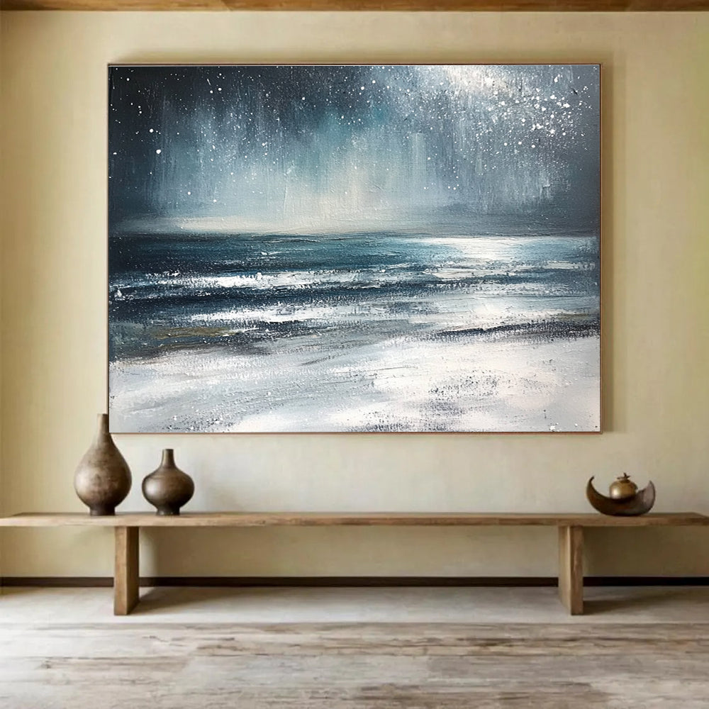 Large abstract painting depicting a winter ocean scene with dark blue and gray tones a starry white sky and sandy beach resembling snow.SC412