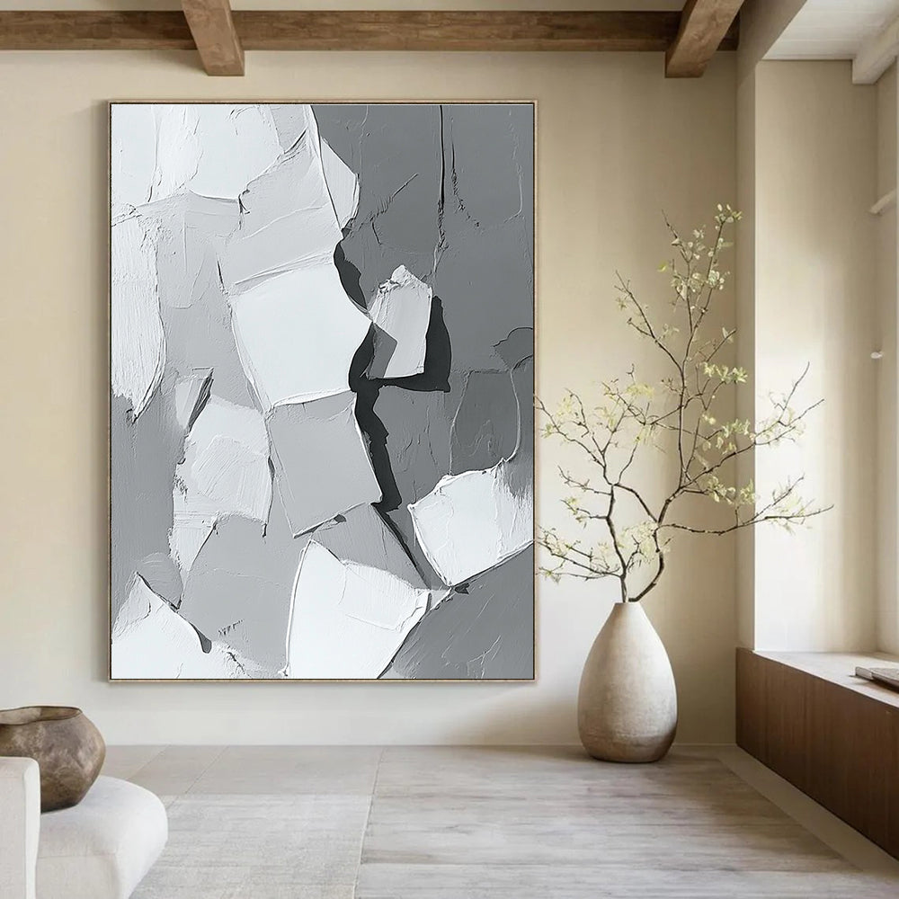 Large abstract painting in gray and white showcasing body parts in armor with bold brush strokes and thick paint application in a striking monochrome palette.STSC479
