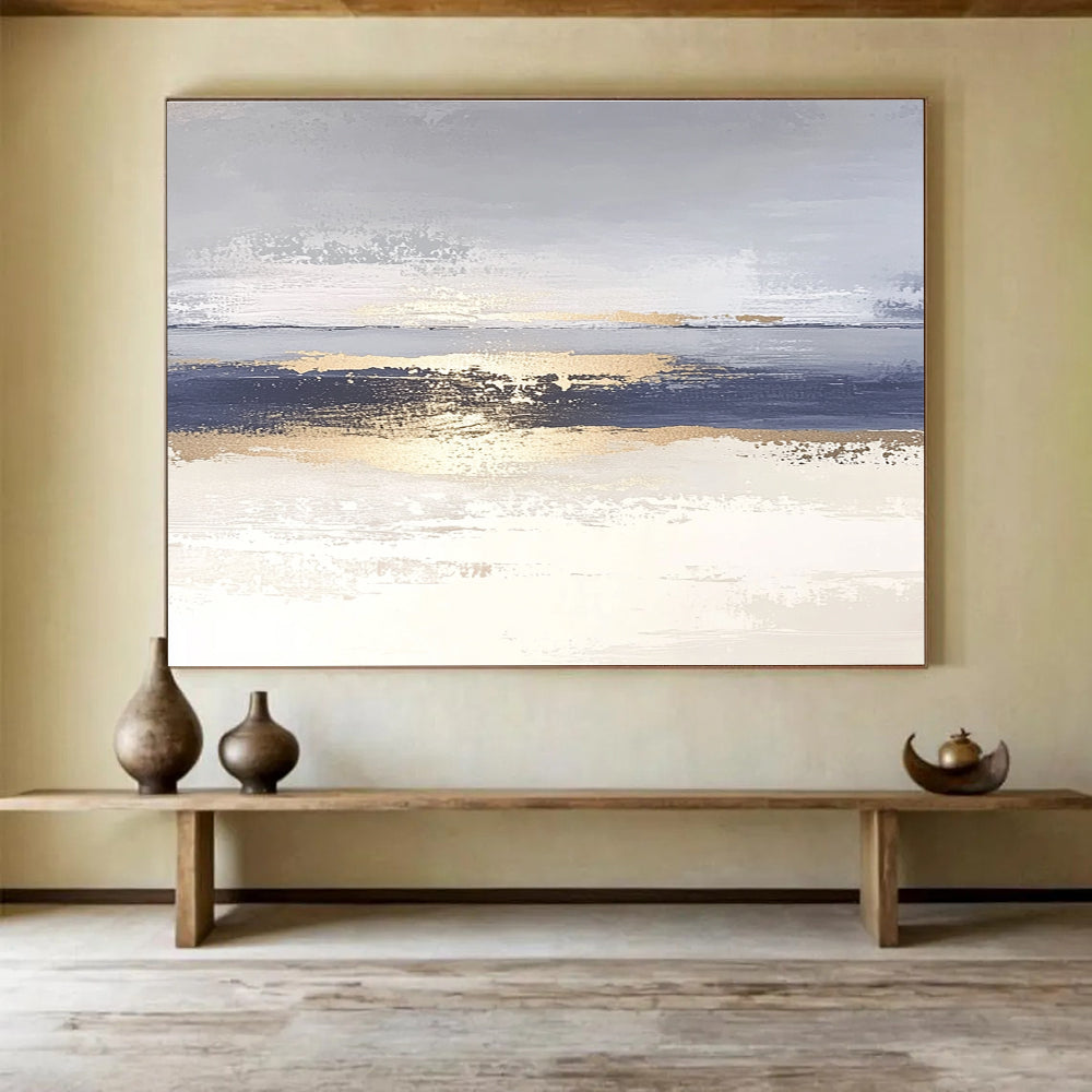 Large abstract painting with soft light blue and gray tones featuring metallic gold lines depicting water ripples on serene sand.SC007