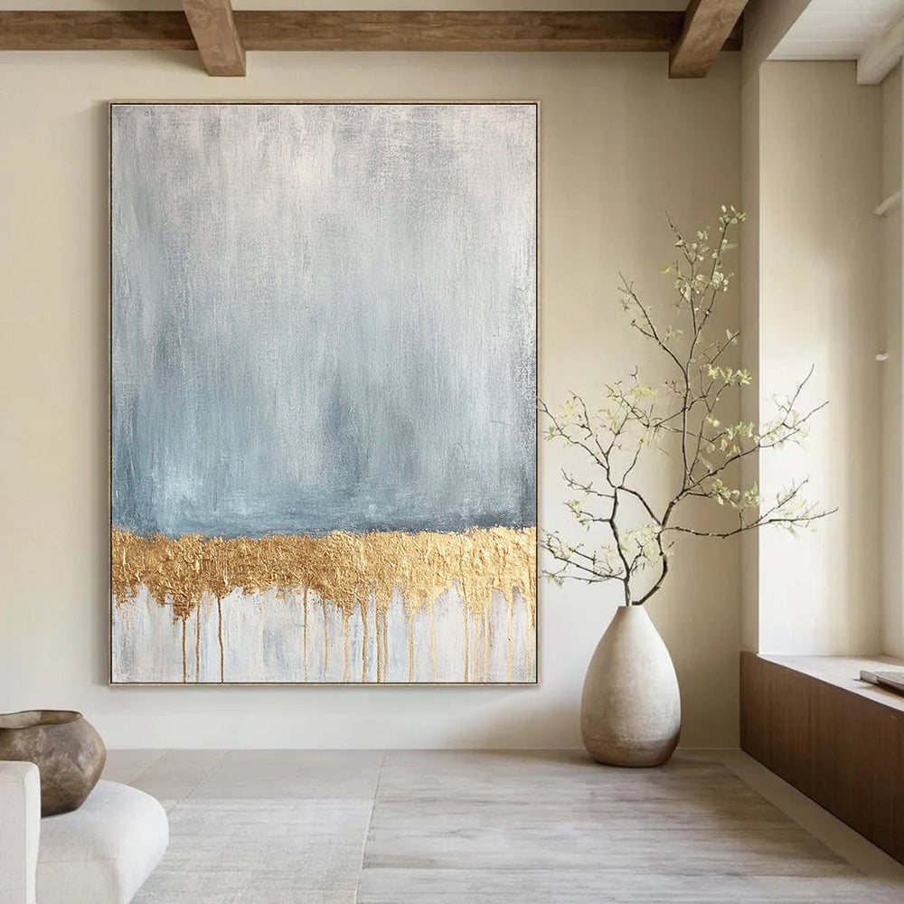 Large abstract painting featuring a textured pale blue and gold palette with a gold metallic foil line across a soft grey and white background.STSC571
