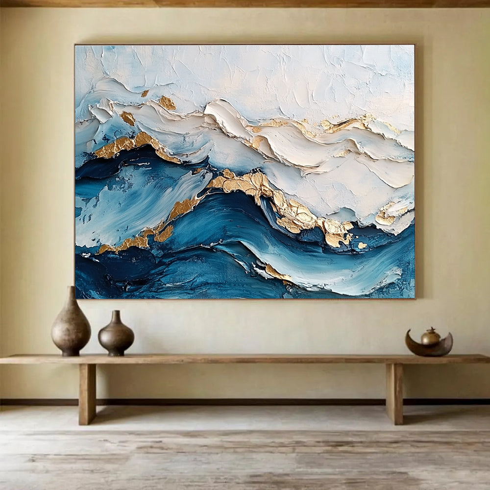 Large abstract painting featuring ocean waves in textured white and blue hues with gold accents for depth and elegance.SC102