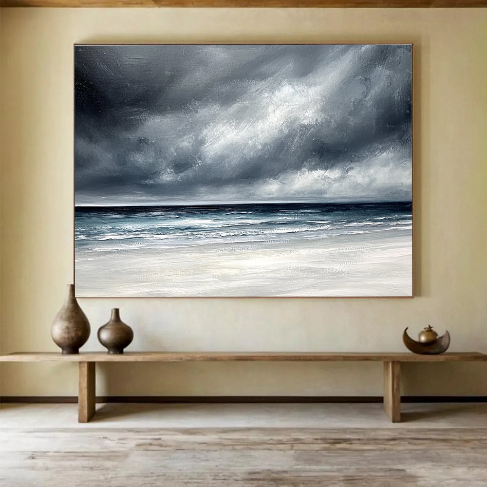 Large abstract painting featuring an ocean with stormy gray clouds and a white sand beach in soft gray and blue tones.SC163