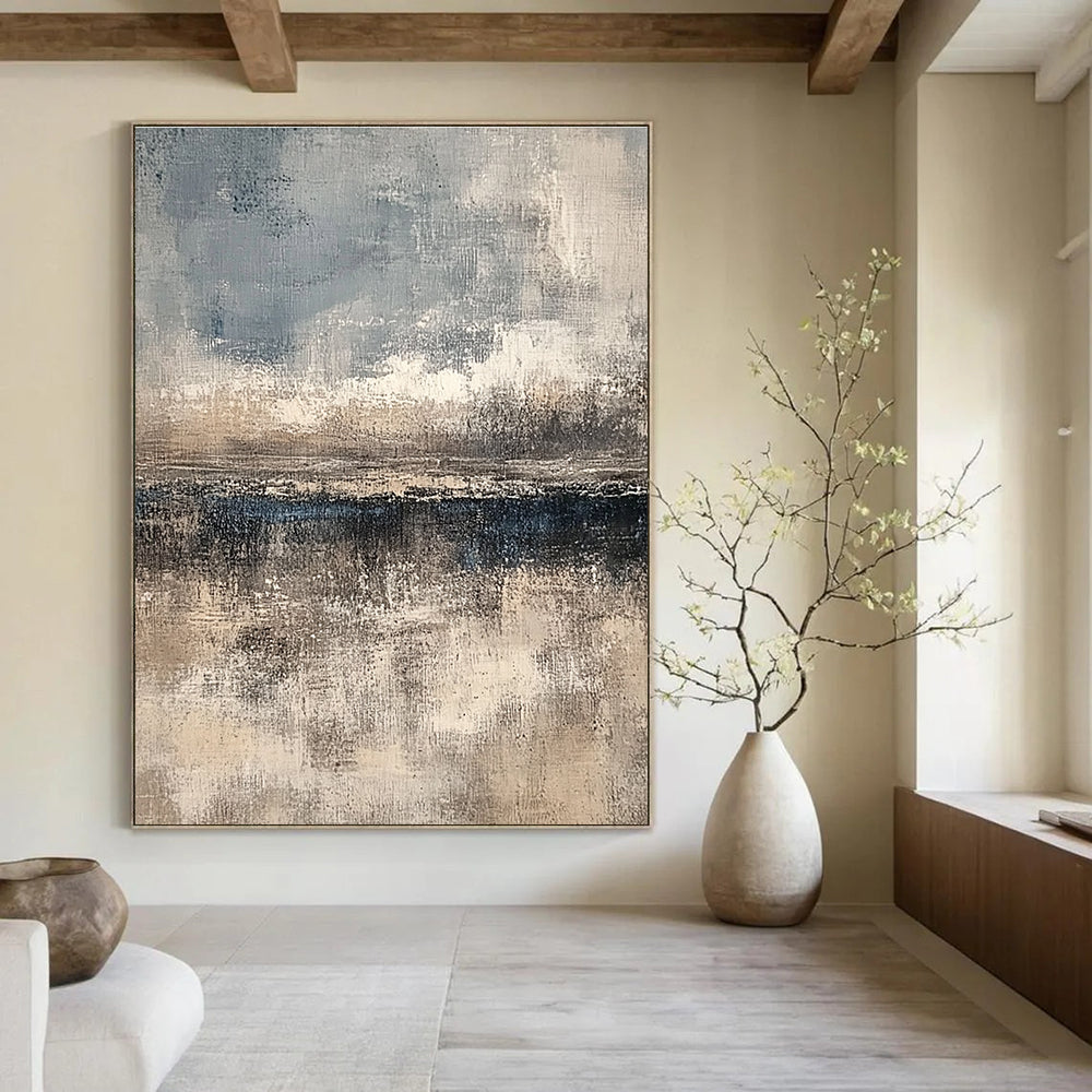 Large abstract painting featuring textured layers in neutral beige and gray with subtle blue and white accents creating depth and a serene horizon line.STSC108