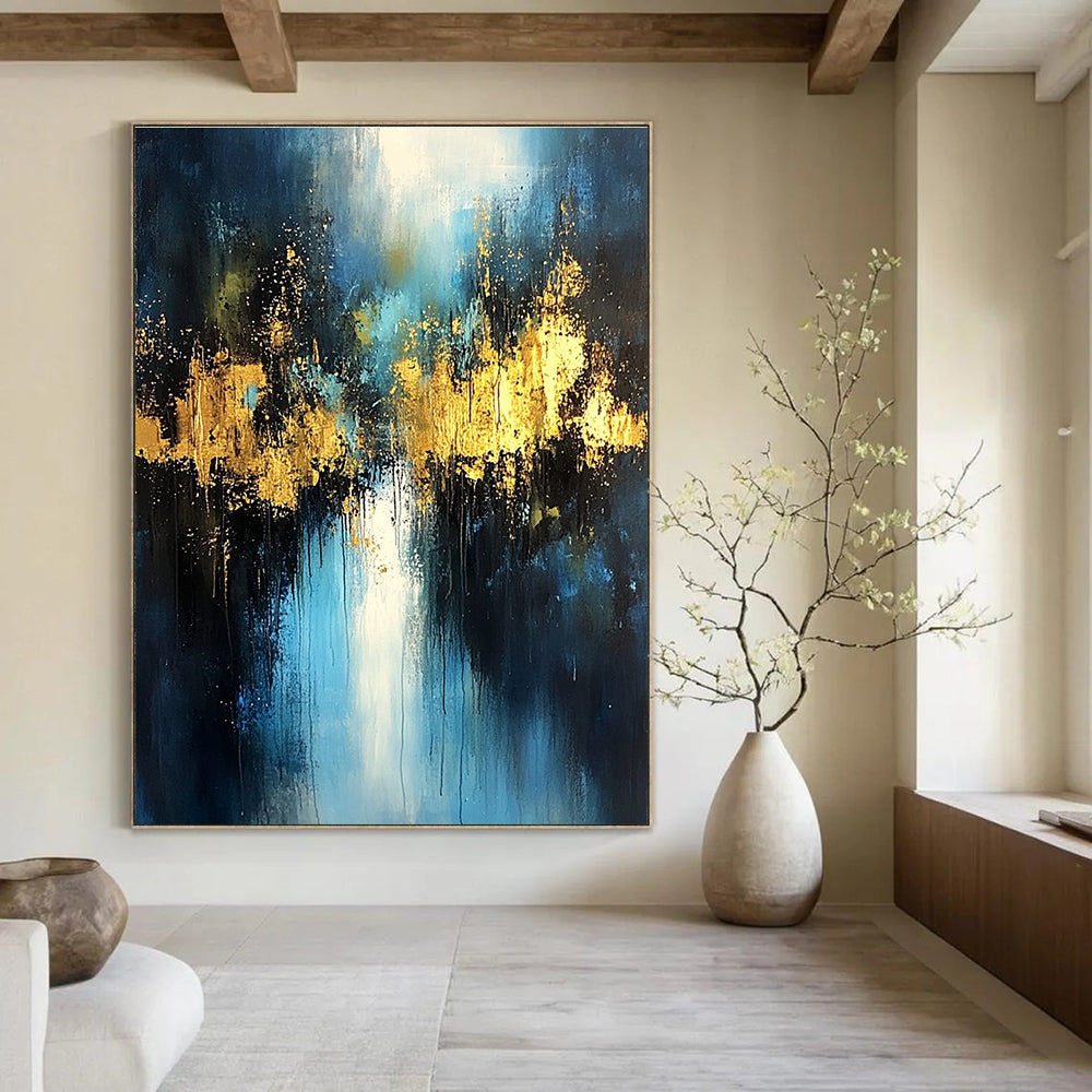 Large abstract painting with light blue and dark gold colors featuring atmospheric brushstrokes gold foil embellishments and a mysterious night scene.STSC399