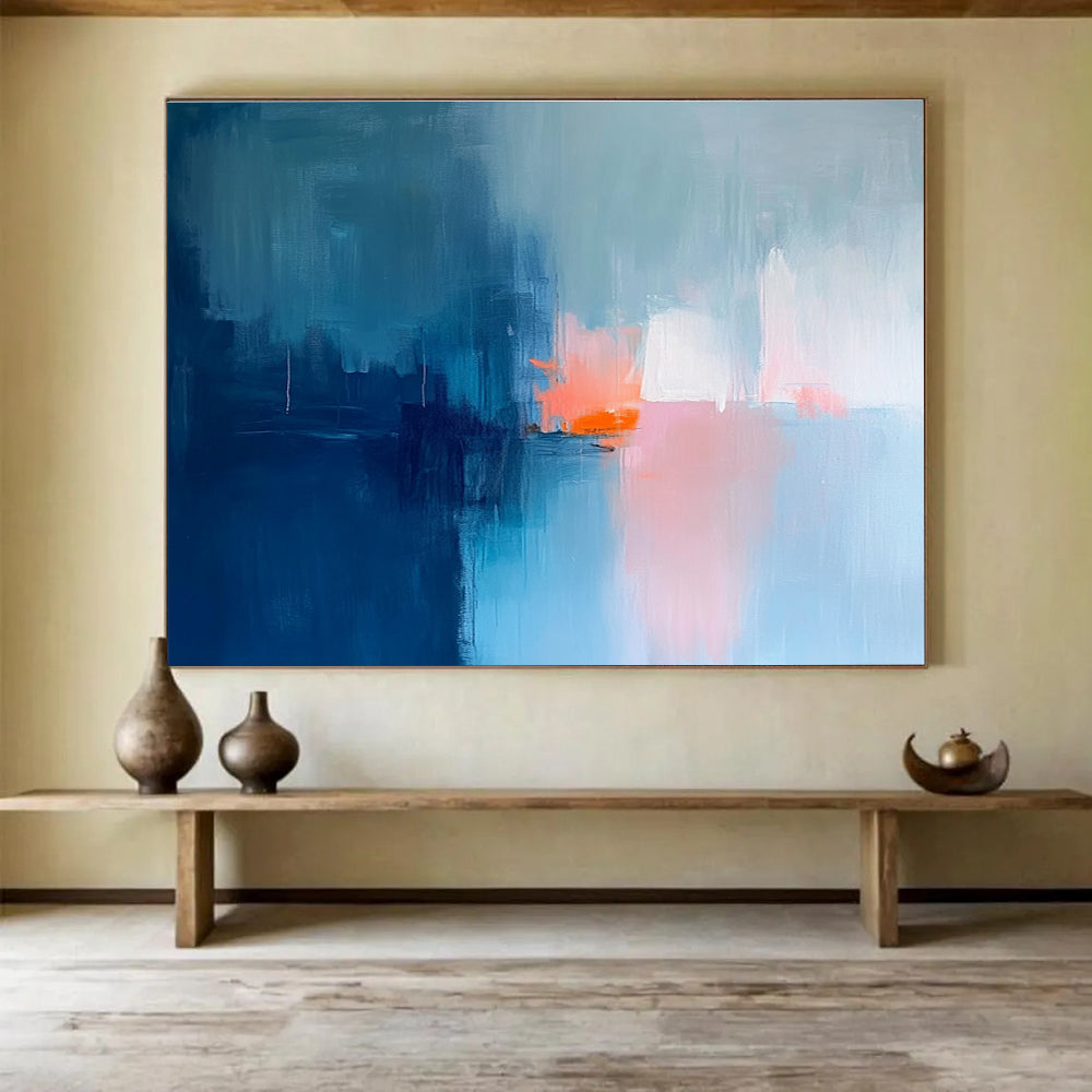 Large abstract painting in soft blue tones with pink and orange accents creates a serene mood through expressive brush strokes and blurred edges.SC253