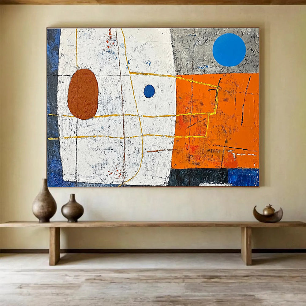 A large abstract painting featuring white squares orange and blue shapes yellow lines a small brown oval and a blue dot on a vibrant orange and dark grey background.SC376