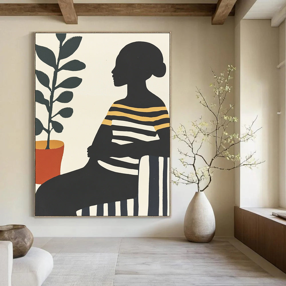 Large abstract painting featuring an African woman on a striped sofa with silhouettes and vibrant colors complemented by a pot of green leaves.STSC537
