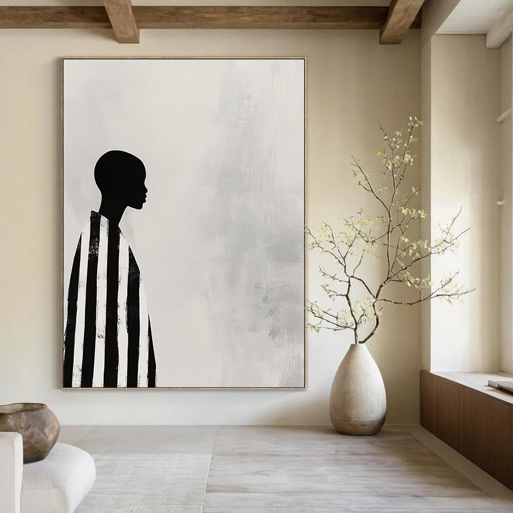 A large abstract painting featuring a striking black and white profile of an African woman in striped robes against a soft gray background.STSC1079