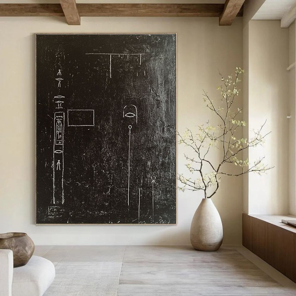 A large abstract painting featuring a black wall adorned with white chalk drawings of ancient Egyptian symbols and writing in high contrast.STSC918