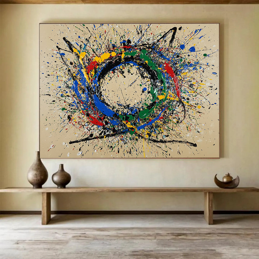 A large abstract painting featuring a circular splash pattern in blue red green yellow and black on a beige background.SC331