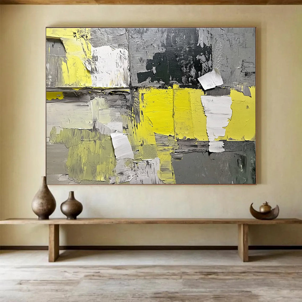 Large abstract painting featuring gray and yellow hues with textured paper elements extending from the wall for added dimension.SC240