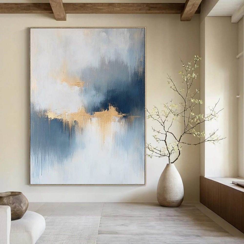 Large abstract painting featuring atmospheric clouds in soft blue gray and white tones with gold and silver accents and delicate textures.STSC386
