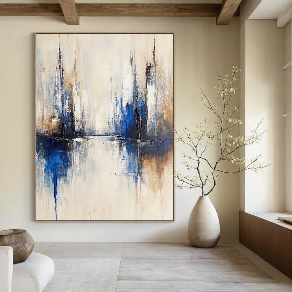 Large abstract painting of a city with muted white and blue tones on a beige background featuring blurred brush strokes reflecting in water.STSC134