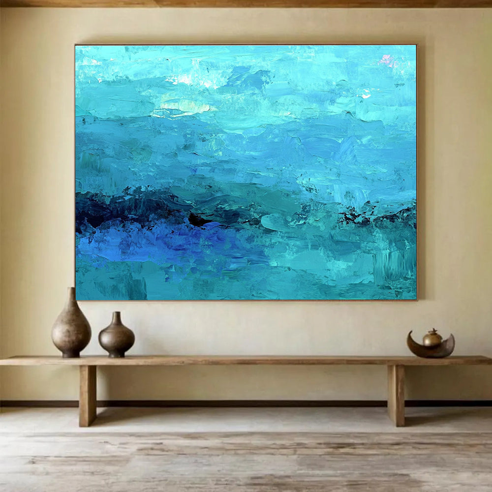 Large abstract painting of the ocean in soft blues and teals showcasing impressionistic waves and a mysterious silhouette beneath gentle mist.SC201