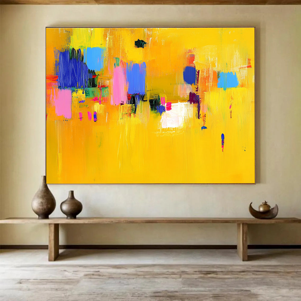 Large abstract painting featuring bold yellow and blue strokes with pink accents dynamic lines and vibrant textures creating an energetic atmosphere.SC147