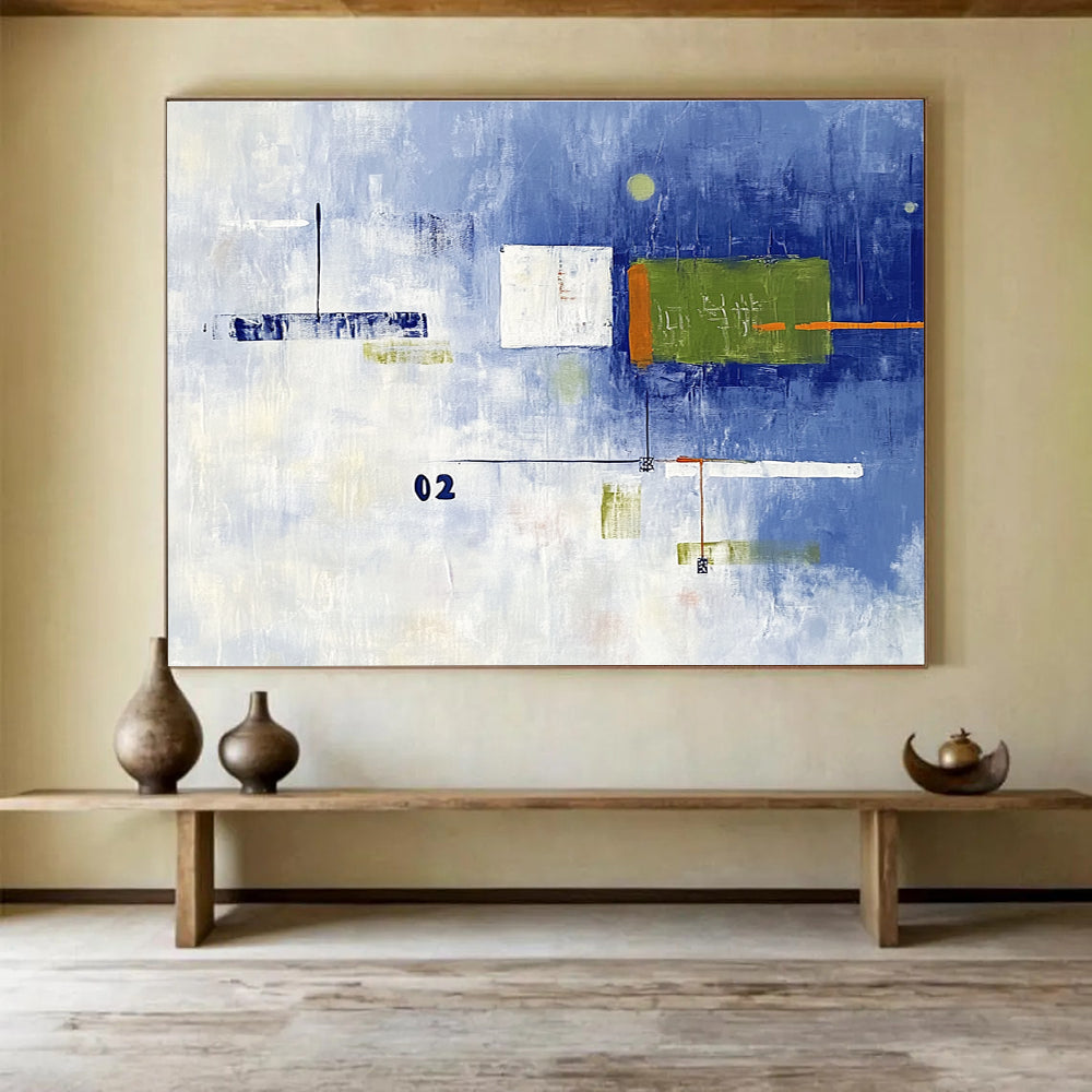 A large abstract painting with broad brush strokes in cool blue and white, featuring bold geometric shapes in green and orange, creating depth and contrast.SC493