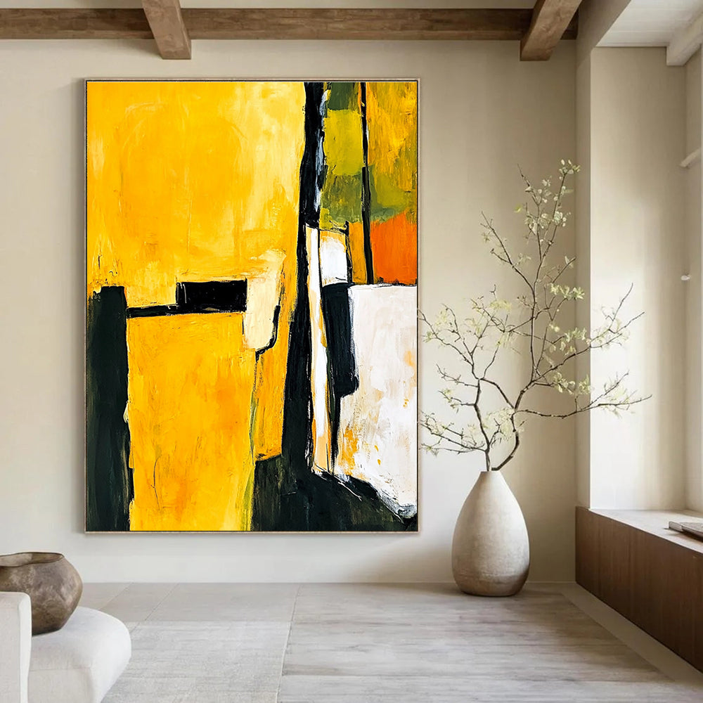 Abstract painting in yellow and black featuring white shapes with a minimalist atmosphere and an armchair in the foreground.STSC718
