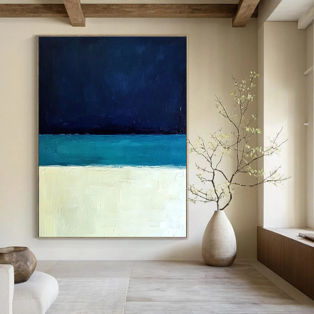 Large abstract painting featuring a minimalist ocean scene with blue tones white sand beach and a dark sky in Rothko style.STSC884