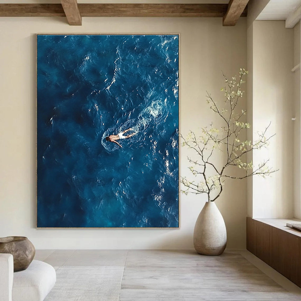 Large abstract painting depicting a solitary man in deep blue ocean waves wearing white swim trunks evoking solitude and calmness amidst chaos.STSC1057