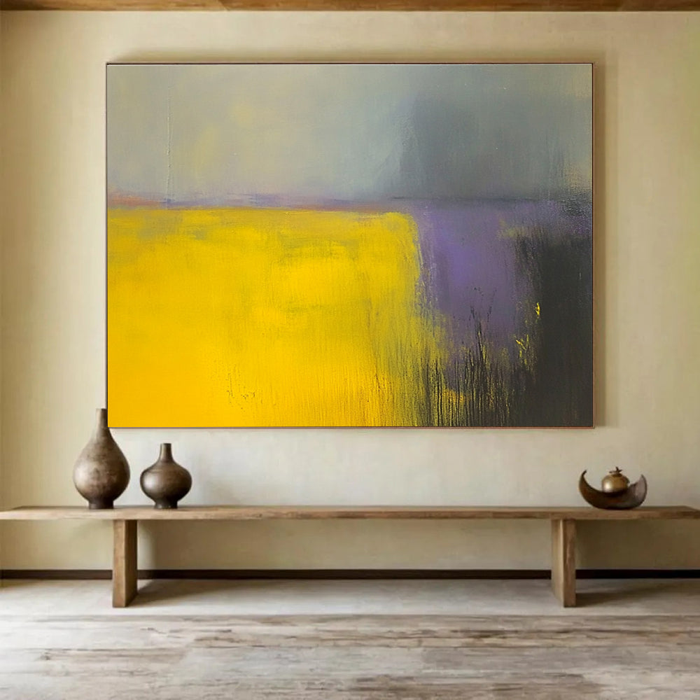 A large abstract painting featuring vibrant yellow and gray fields with subtle purple hues, enhanced by dynamic brushstrokes and a blurred background.SC475