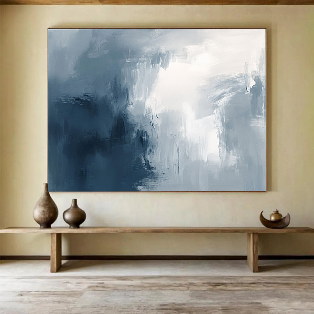 Large abstract painting with broad brush strokes in gray white and navy blue evoking calmness and introspection through soft gradients.SC048