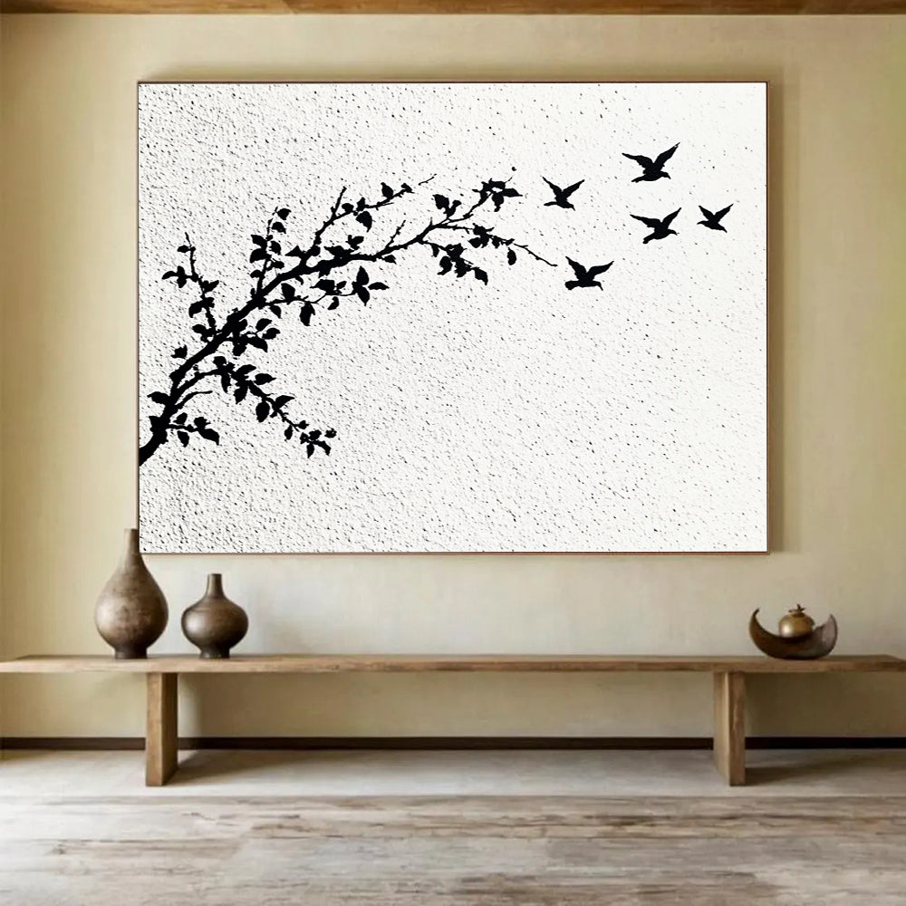 A large abstract painting featuring delicate branches with leaves and black and white flying birds against an off-white wall.SC434