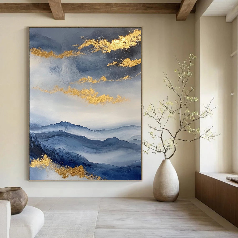 Large abstract painting featuring a beautiful sky mountains and clouds in blue and gray with gold foil accents.STSC279