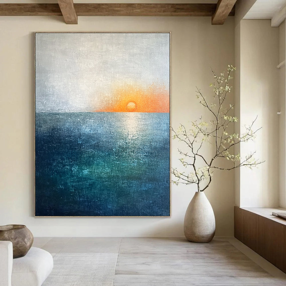 Large abstract painting featuring a soft sky blue and teal gradient with a grey expanse and a small orange sun setting on the horizon.STSC094