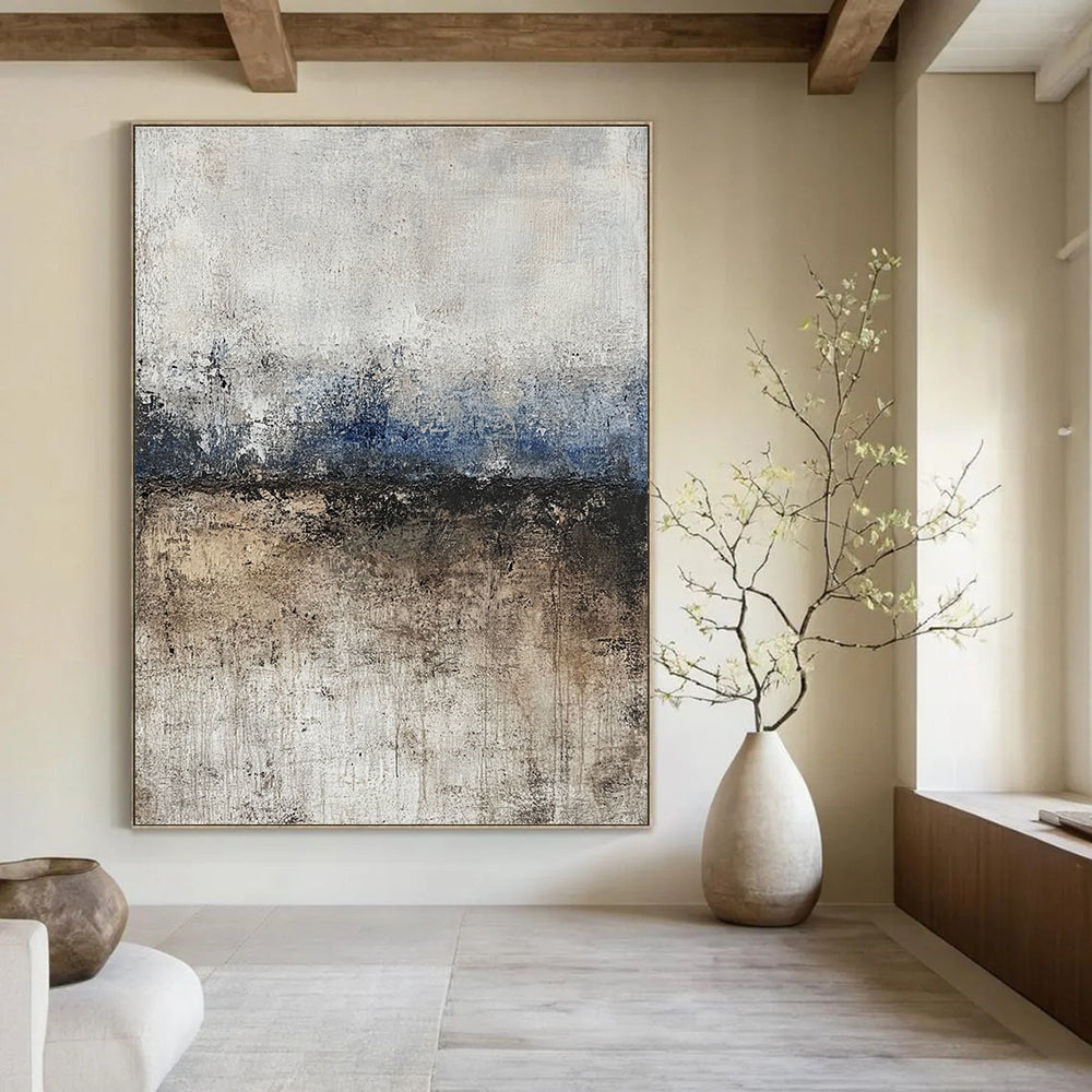 Large abstract painting featuring soft edges and subtle color transitions of beige blue-gray and brown with a path leading to tranquil water.STSC125