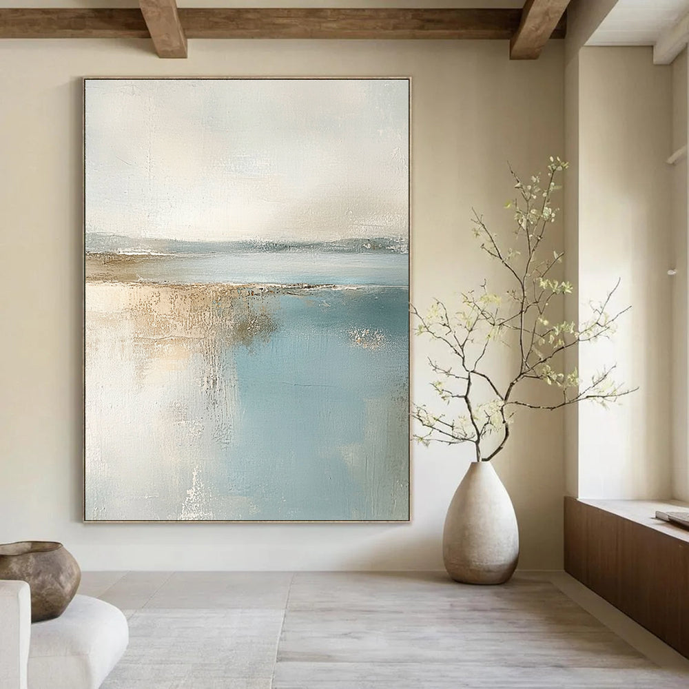 Large abstract painting featuring muted pastel colors of beige and light blue creating a calming beach landscape in neutral tones.STSC017