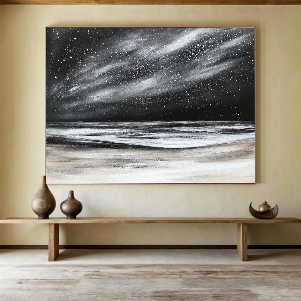 Large abstract painting depicting a dark stormy sky with stars and snow on the beach in black and white colors.SC295