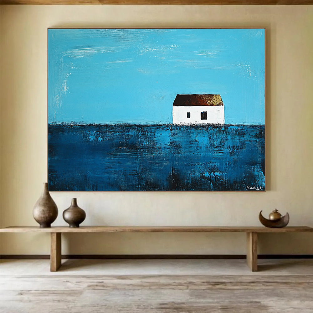 A large abstract painting featuring a small white house on the horizon surrounded by deep blue sea in the style of Anna Bocek.SC553