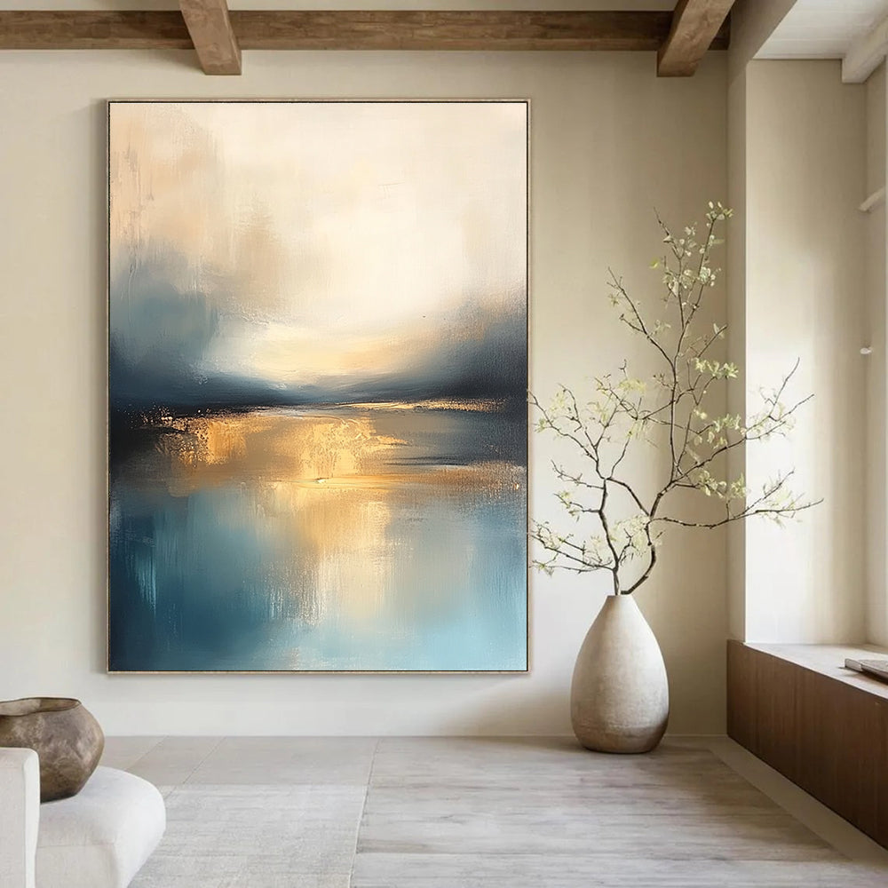 Large abstract painting featuring soft blue and gold tones with a calm sea reflections dramatic clouds and a tranquil sky.STSC103