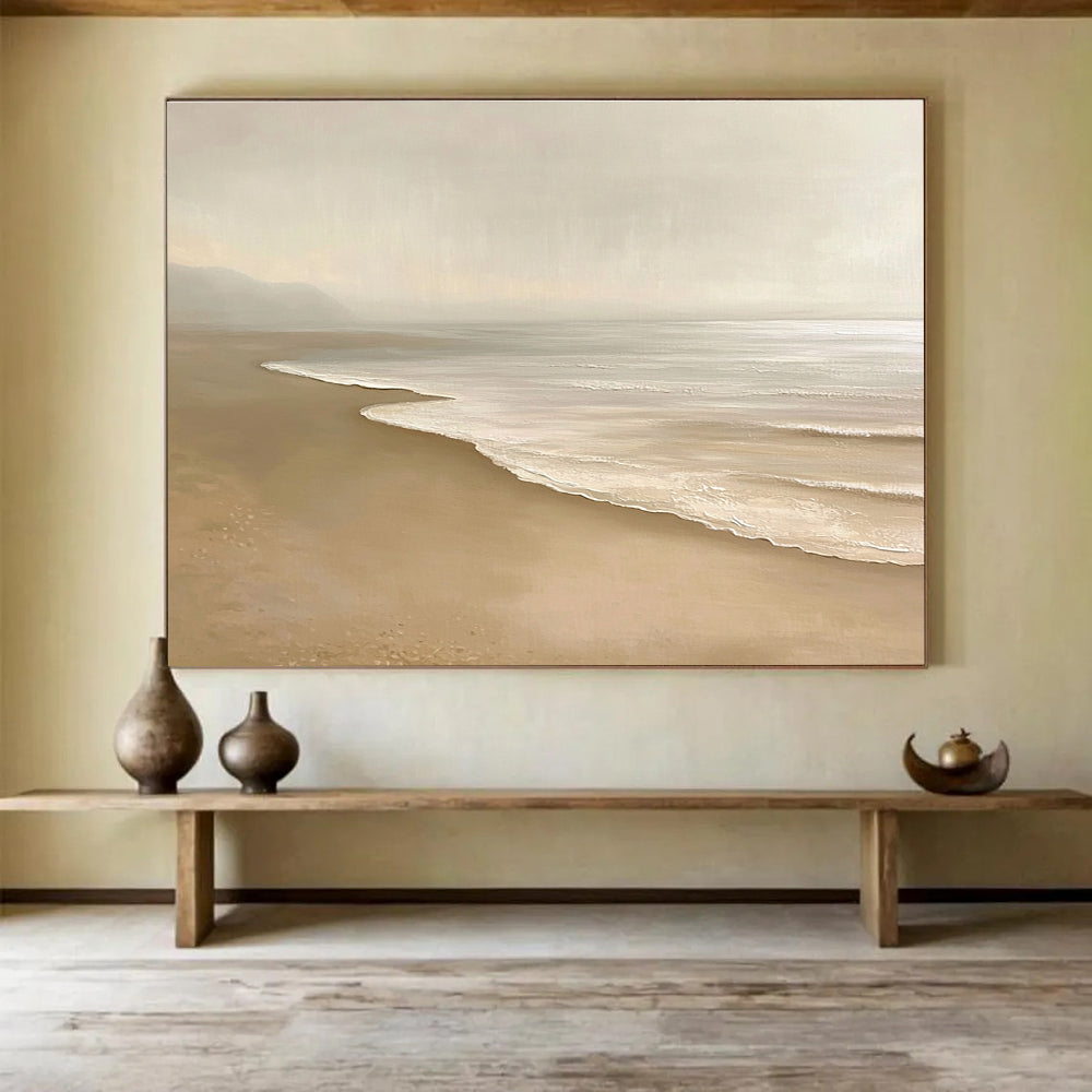 Large abstract painting featuring a serene beach with beige and white tones capturing gentle waves and soft sand in a tranquil setting.SC424