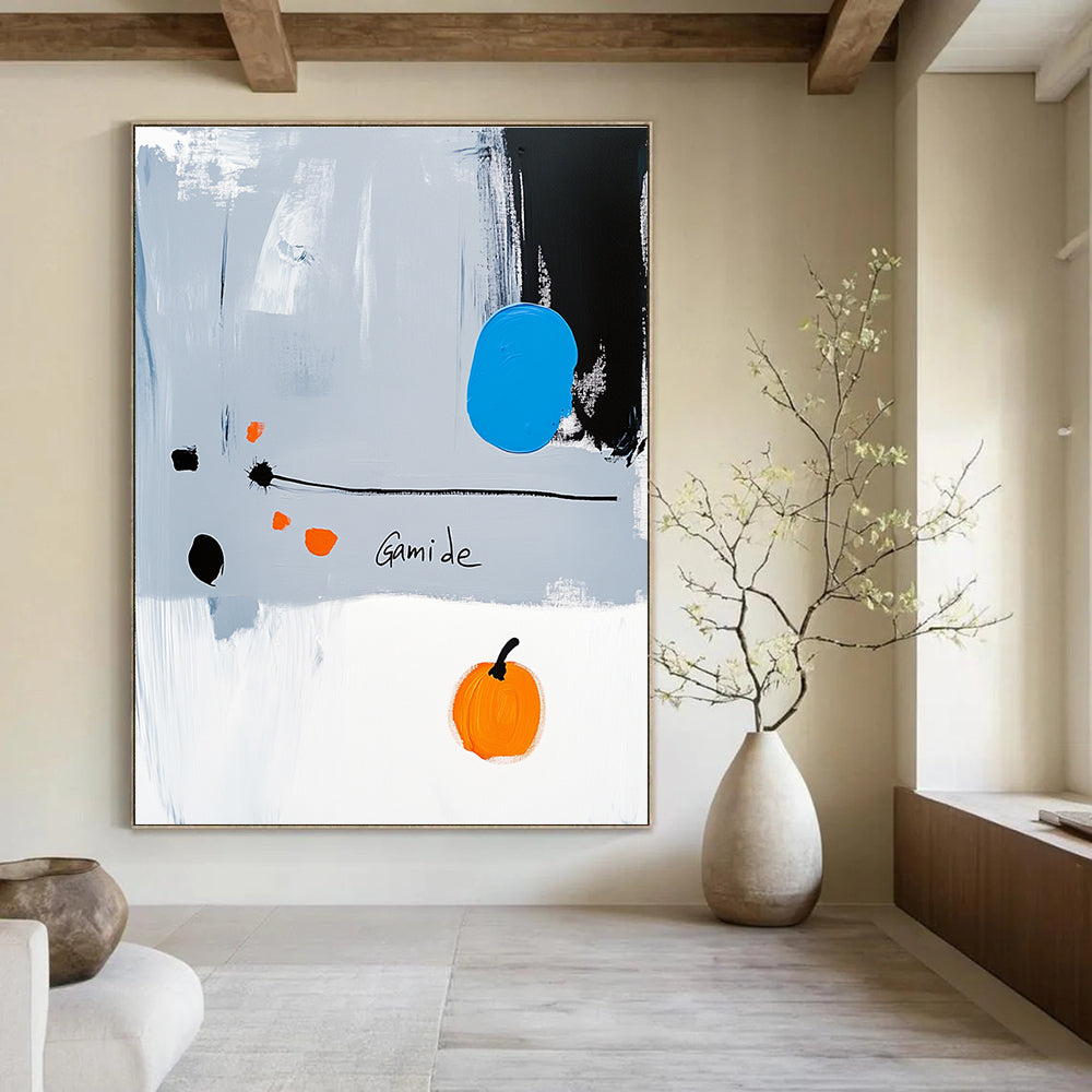 Abstract painting of a right-pointing arrow in blue white gray orange and black with Gamide text and a cartoonish pumpkin on light gray background.STSC1073