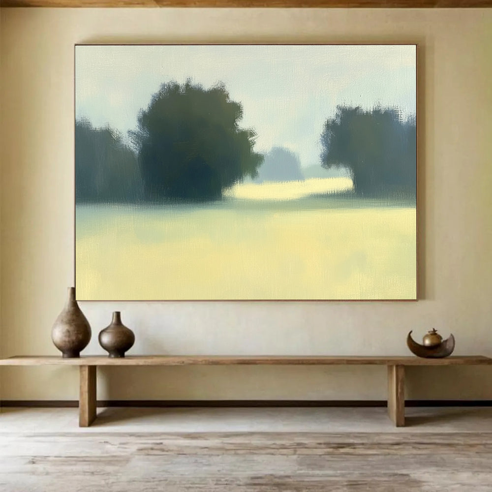 A large abstract painting featuring impasto technique with soft hues of green and yellow depicting a hazy field with distant trees.SC498