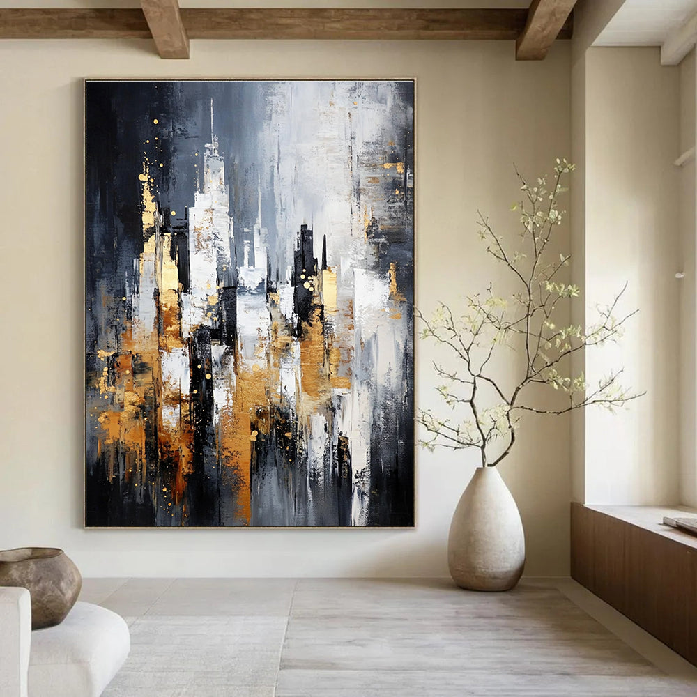 Large abstract painting of a cityscape in gray and white with gold accents on a dark background featuring neutral tones.STSC282