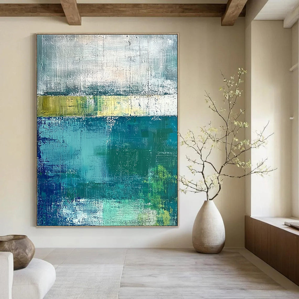 Large abstract painting with green and blue tones on a gray background evokes a serene water's edge mood with textured surfaces.STSC420