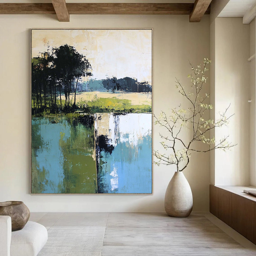 Large abstract painting featuring green blue and beige hues with distant trees foreground trees and green grass by the water.STSC098