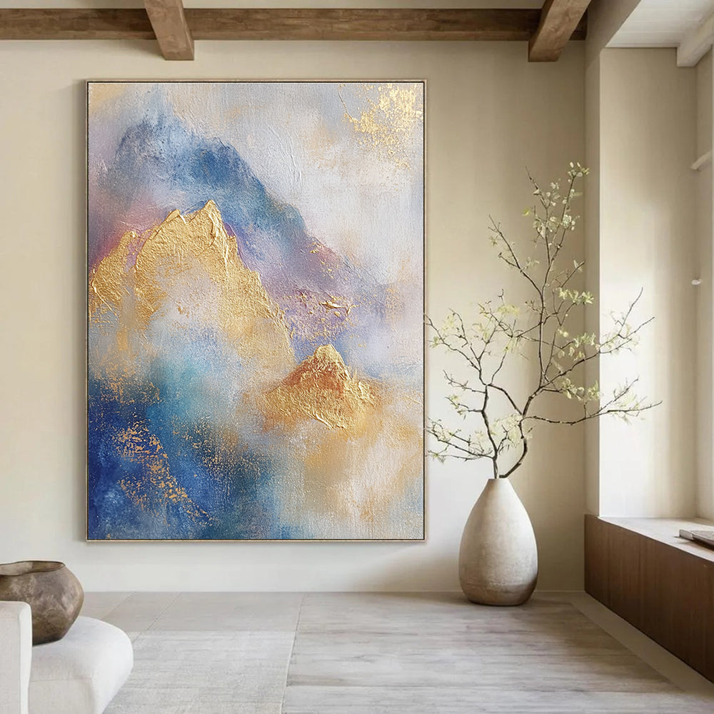 Large abstract painting featuring soft blue and gold tones with gilded mountains and textured brushstrokes for a striking visual impact.STSC446
