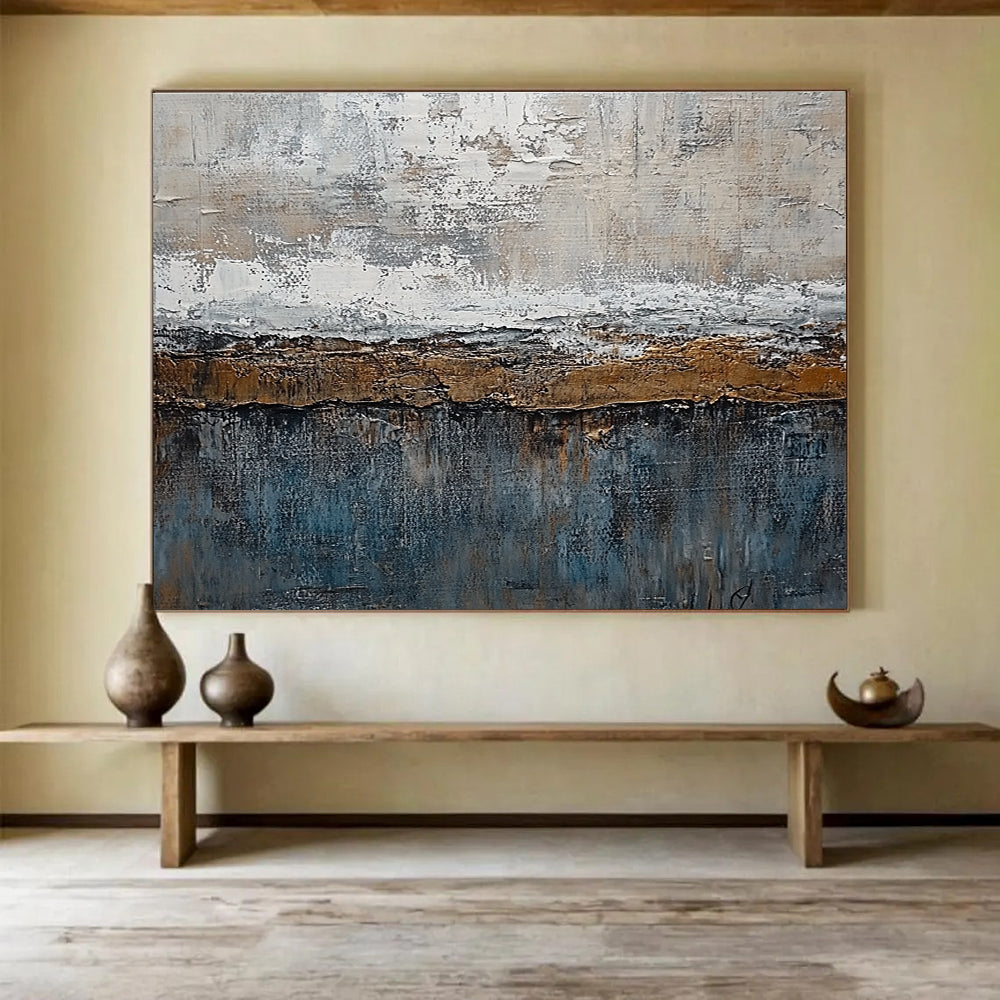 Large abstract painting features textured layers of grey, brown, blue, and bronze with painterly strokes and metal accents creating an artistic landscape.SC174