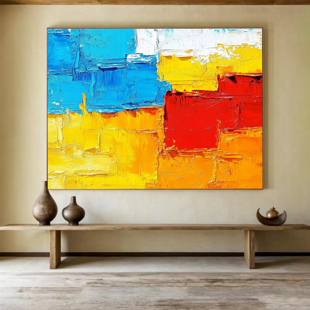 Large abstract painting featuring textured impasto brushstrokes in warm sunset tones of orange red yellow and blue.SC261
