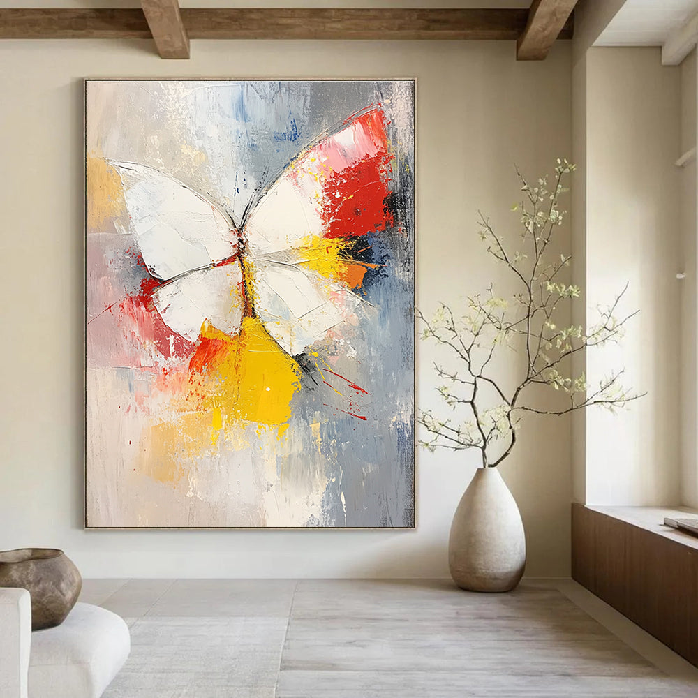 Large abstract painting featuring a white and red butterfly with vibrant yellow feathers set against a soft gray and pink background.STSC552