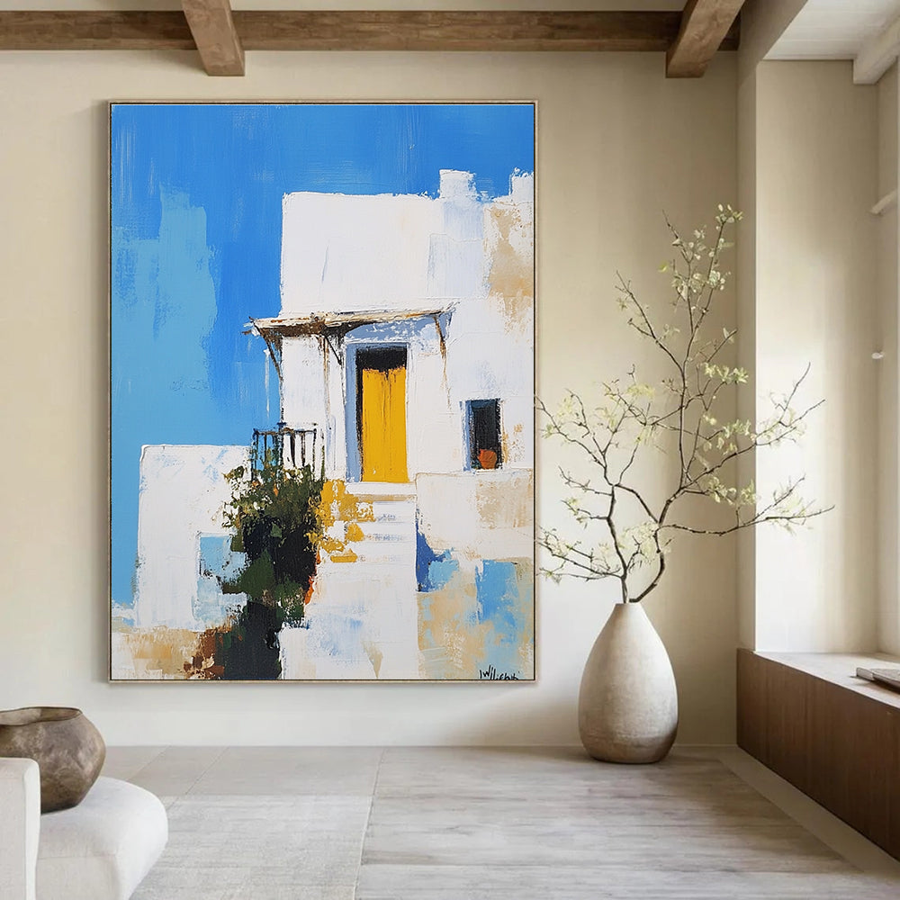 An abstract painting featuring a white Greek-style house with a yellow door against a blue sky inspired by Peter Wileman.STSC1253