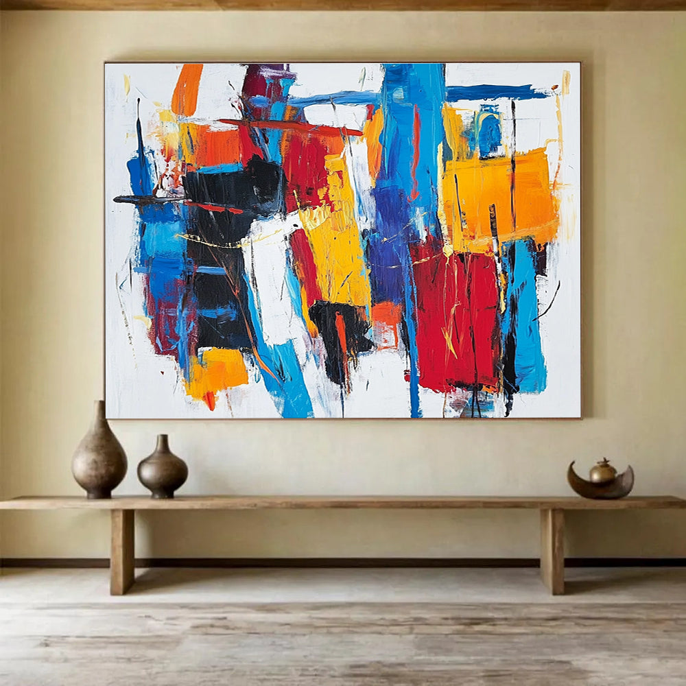 Large abstract painting with thick brush strokes and vibrant reds blues and yellows creating a unique abstract cityscape on a white background.SC262
