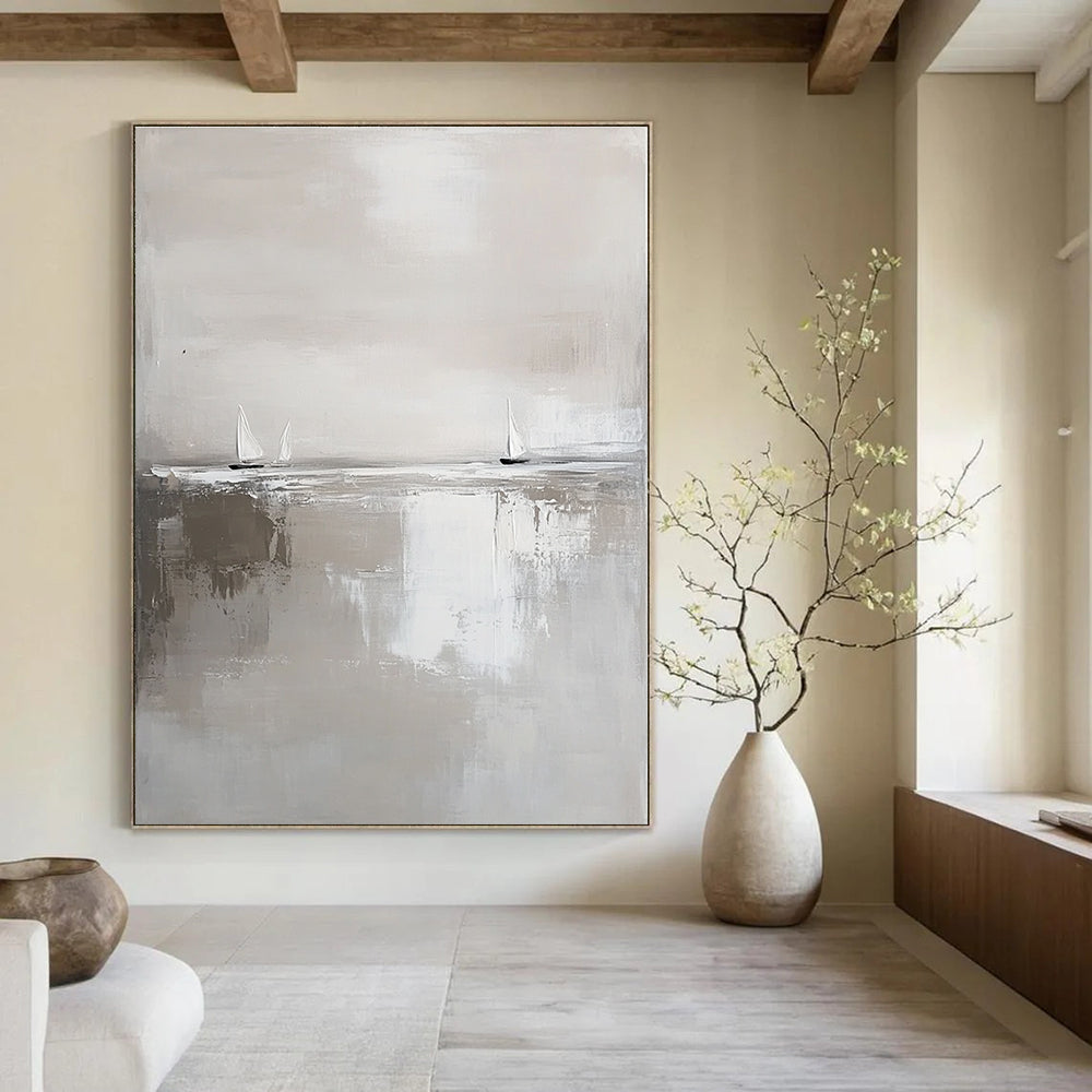 Large abstract painting in white and gray featuring calm waters and distant sailboats in a minimalist style with neutral tones.STSC359