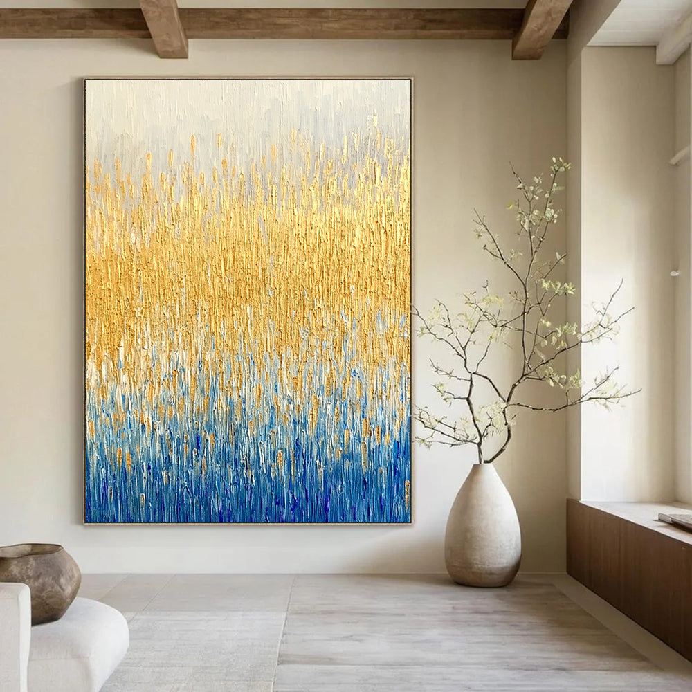 Large abstract painting of a textured wheat field in gold and blue hues showcasing fine art style and neutral tones.STSC291